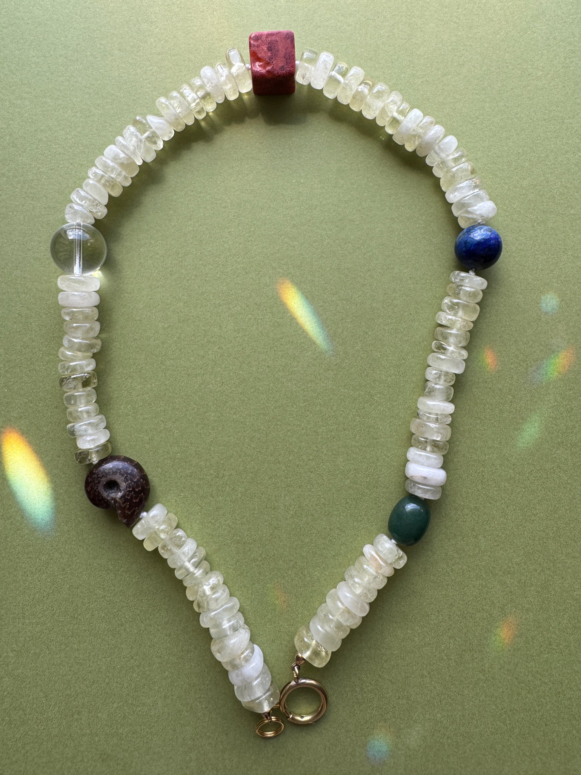 Necklace with multicolored beads on a green background